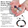 A hand holds several raw natural crystals and a black beaded bracelet with various colored stones.