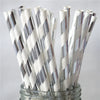 A glass jar filled with a pack of white drinking straws decorated with silver and gray stripes.
