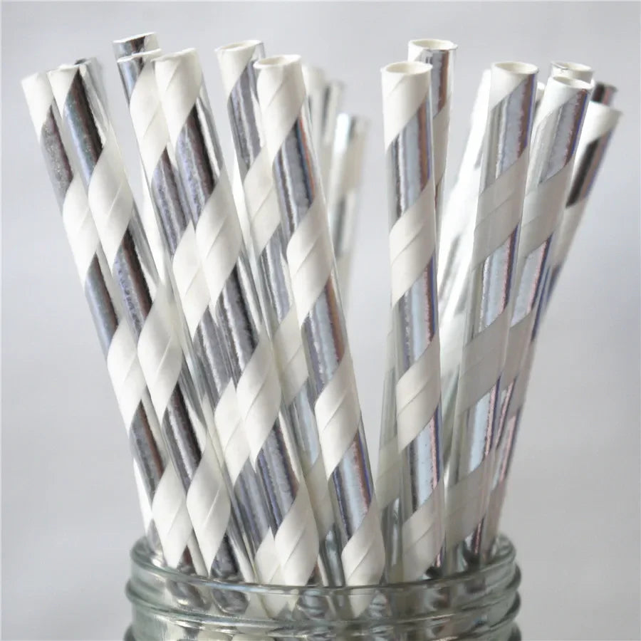 A glass jar filled with a pack of white drinking straws decorated with silver and gray stripes.