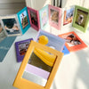 A collection of colorful magnetic photo frames and fridge magnets displayed on a white surface.