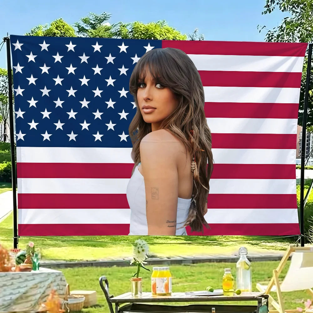 A woman posing in front of a large American flag backdrop.