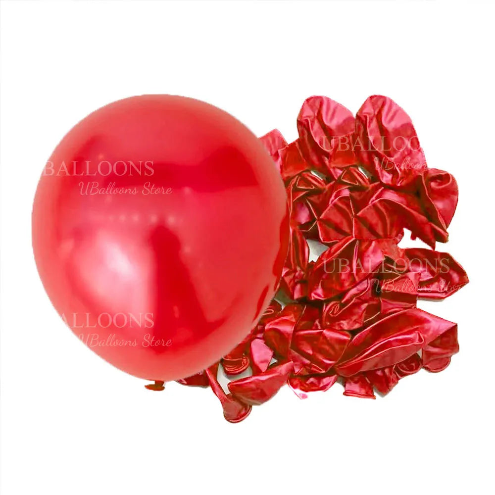 A single glossy red latex balloon next to a bunch of deep burgundy red satin ribbons.