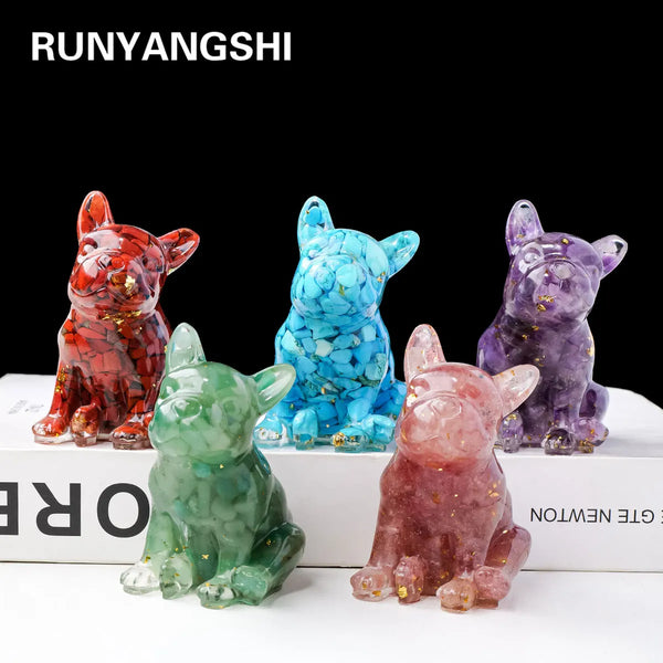Un ensemble de trois statues de chiens en cristal naturel rouge, bleu et violet assis sur une surface blanche.