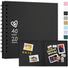 A black spiral-bound notebook with a heart design and a spread showing various photo layouts for a scrapbook album.