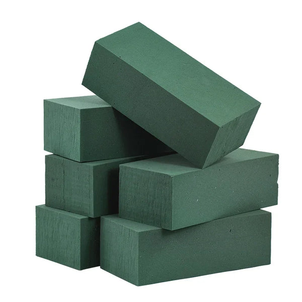A stack of dark green wet floral foam blocks used for party decor.