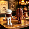 A 3D printed coffee bean cup figurine with articulated joints, brown and white, displayed on a wooden surface.