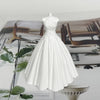 A white silicone mold shaped like a wedding dress for making candles or chocolate.