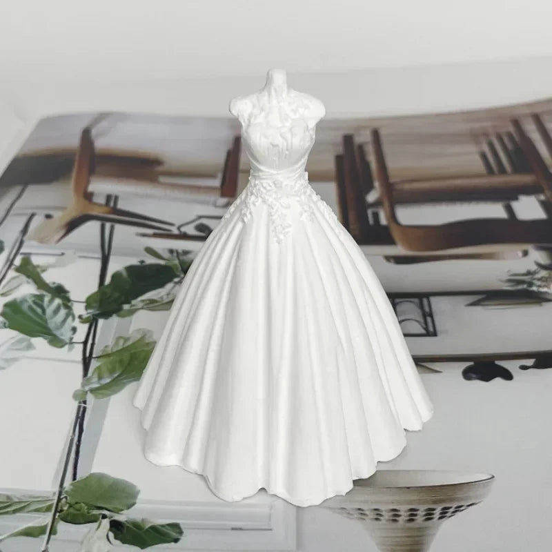 A white silicone mold shaped like a wedding dress for making candles or chocolate.