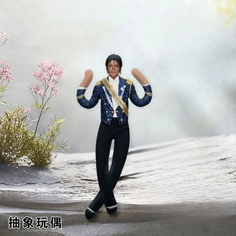 A collectible plush doll of Michael Jackson in a blue and gold outfit standing on a snowy surface.