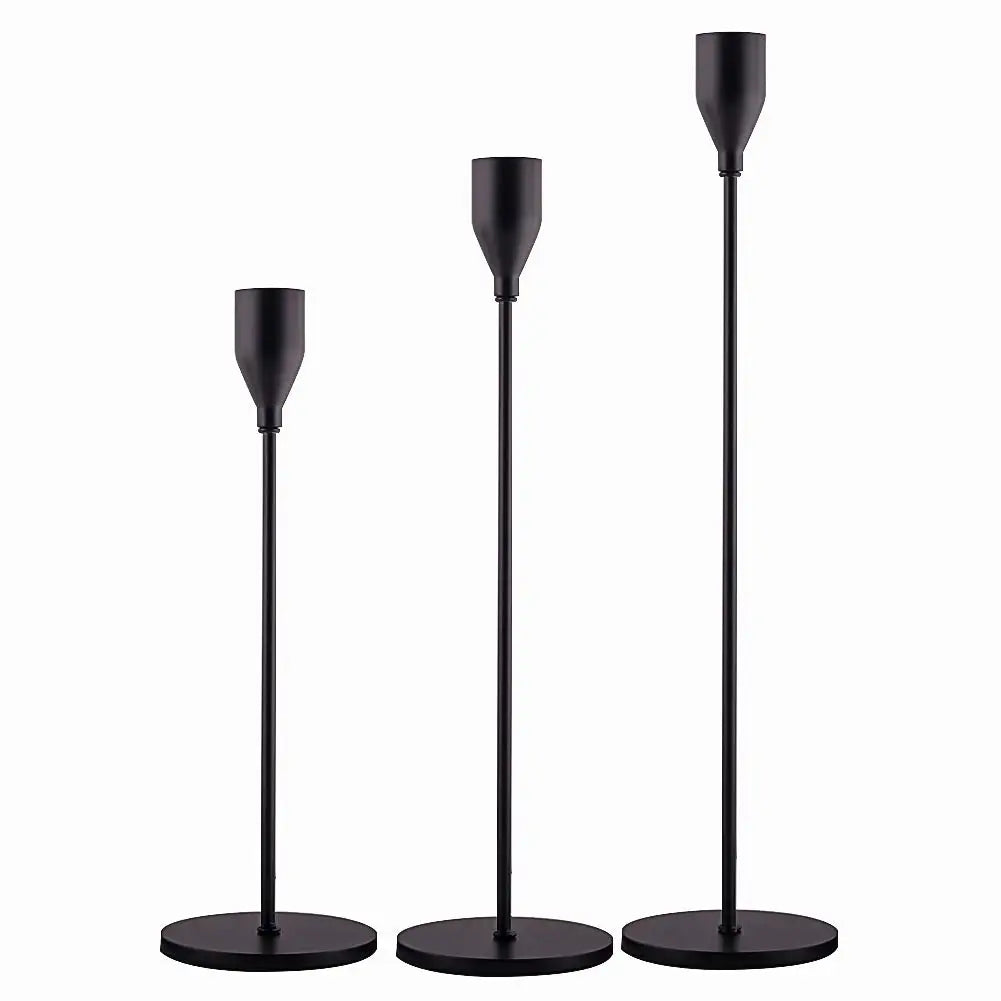 A set of three elegant black metal candle holders with tall, slender arms.