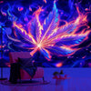 A vibrant neon cannabis leaf tapestry wall hanging illuminates a room with purple and pink light.