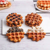 A display of various waffle foods including blueberry waffles, syrup-drizzled waffles, and waffles topped with whipped cream.
