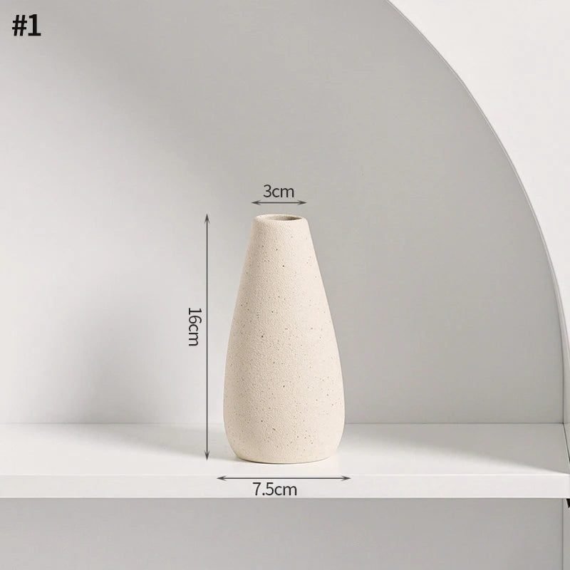 A tall, smooth, beige ceramic vase with a conical shape displayed on a white shelf.