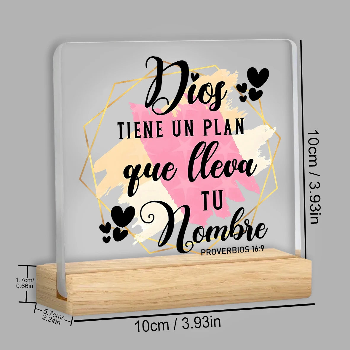 A wooden sign with a gold geometric border features the text Dios tiene un plan que lleva tu Nombre from Proverbs 16:9