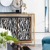 A display of gold-framed clocks and a zebra print self-adhesive wallpaper on a modern shelf.