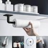 A hand holds a white roll of adhesive cap holder hooks for wall mounted hat storage against a white shelf.