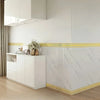 White kitchen cabinetry featuring a self-adhesive PVC baseboard trim with a brick pattern and gold accent.