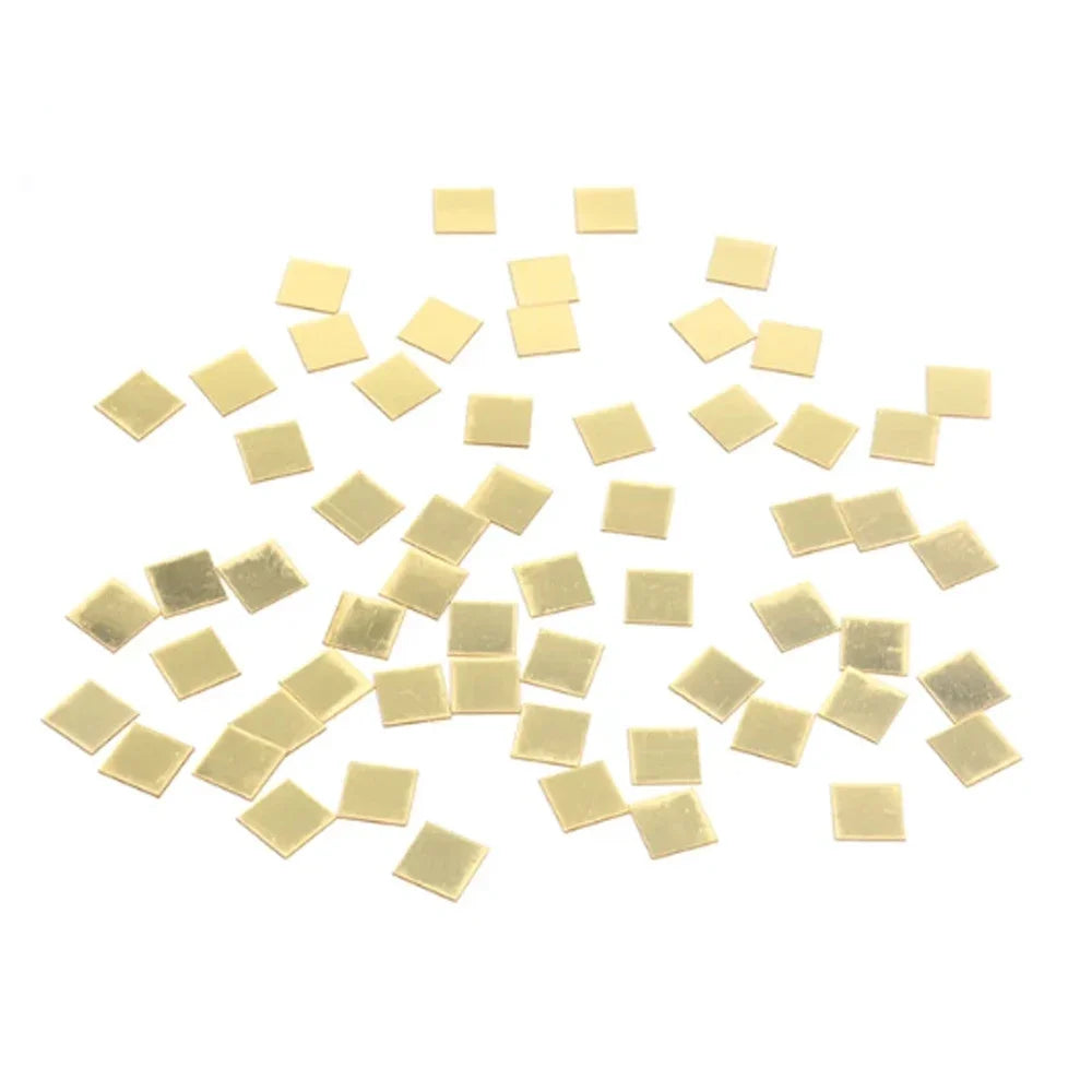 A scattered collection of small, square gold mosaic mirror wall decals.