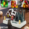 A detailed illuminated Christmas village scene featuring a red house, Santa, and snowy evergreen trees.