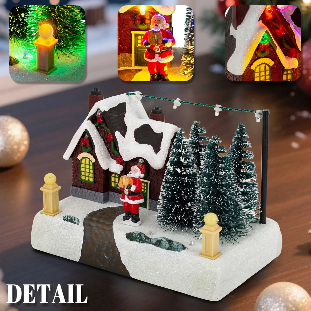 A detailed illuminated Christmas village scene featuring a red house, Santa, and snowy evergreen trees.
