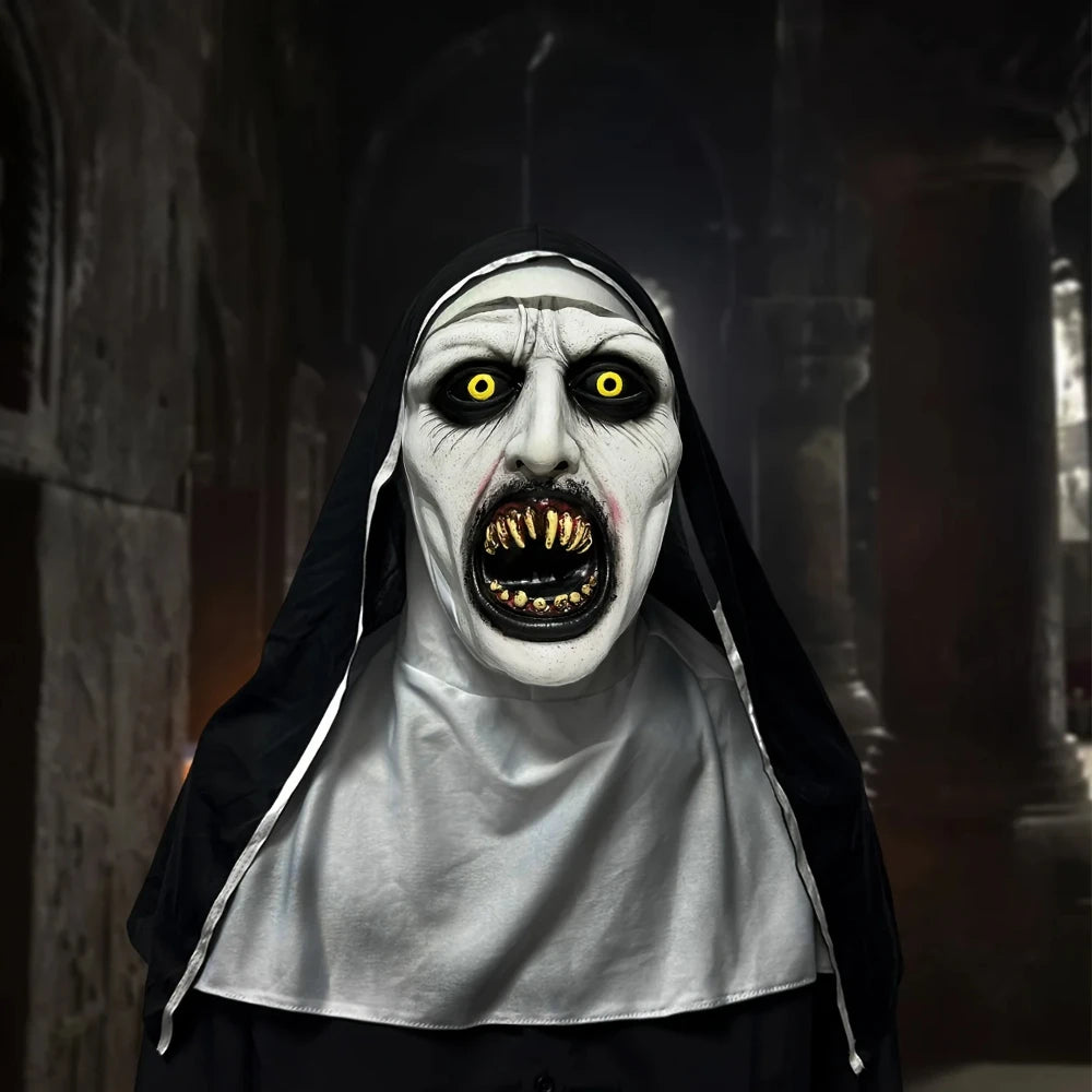 A realistic horror nun latex mask with pale white face, black veil, and glowing yellow eyes.