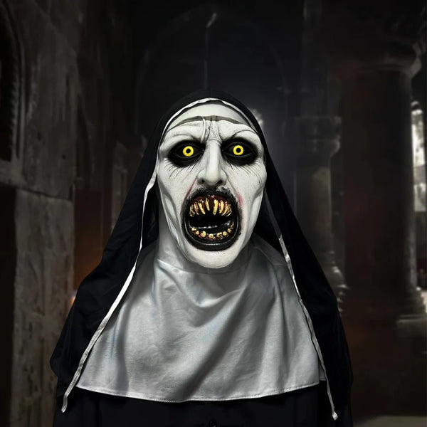 A realistic horror nun latex mask with pale white face, black veil, and glowing yellow eyes.