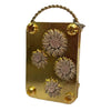 A small brass metal tag with a textured flower design and a twisted wire loop for a mini flower press kit.