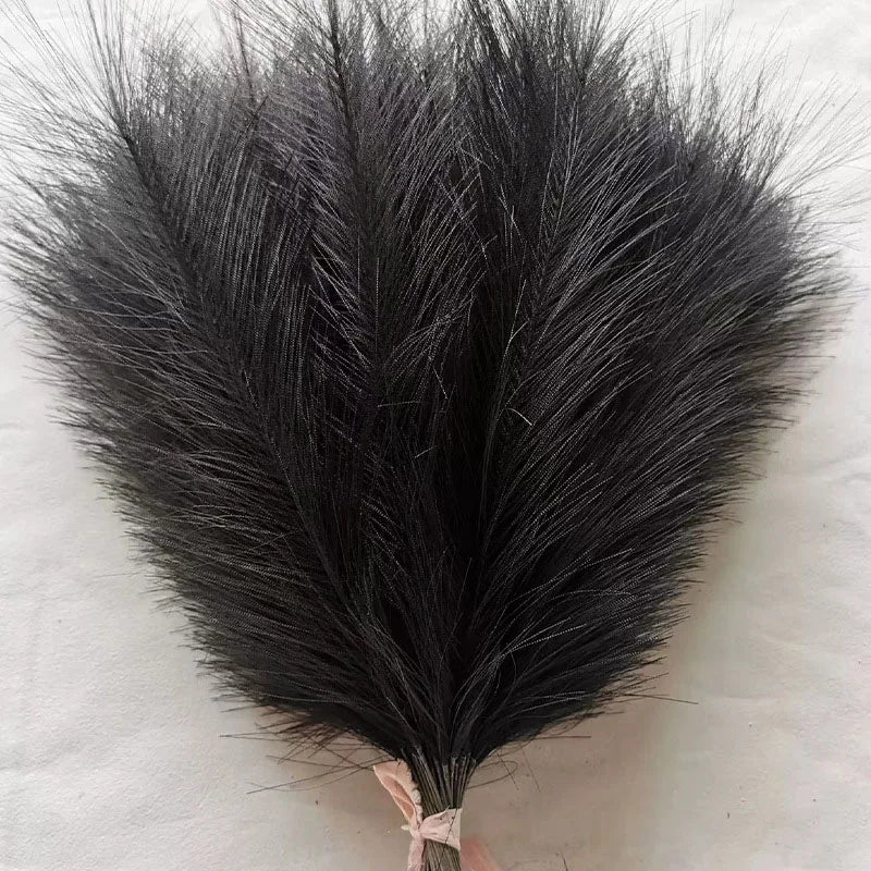 A bundle of black artificial pampas grass stems used for boho wedding and home decor.
