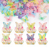 A collection of pink, blue, and yellow butterfly-shaped edible toppers decorating cupcakes.