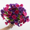 A bouquet of artificial pansy flowers in shades of purple and pink with green eucalyptus stems.