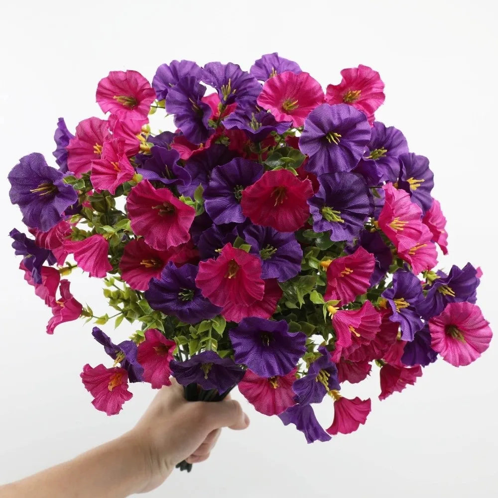 A bouquet of artificial pansy flowers in shades of purple and pink with green eucalyptus stems.