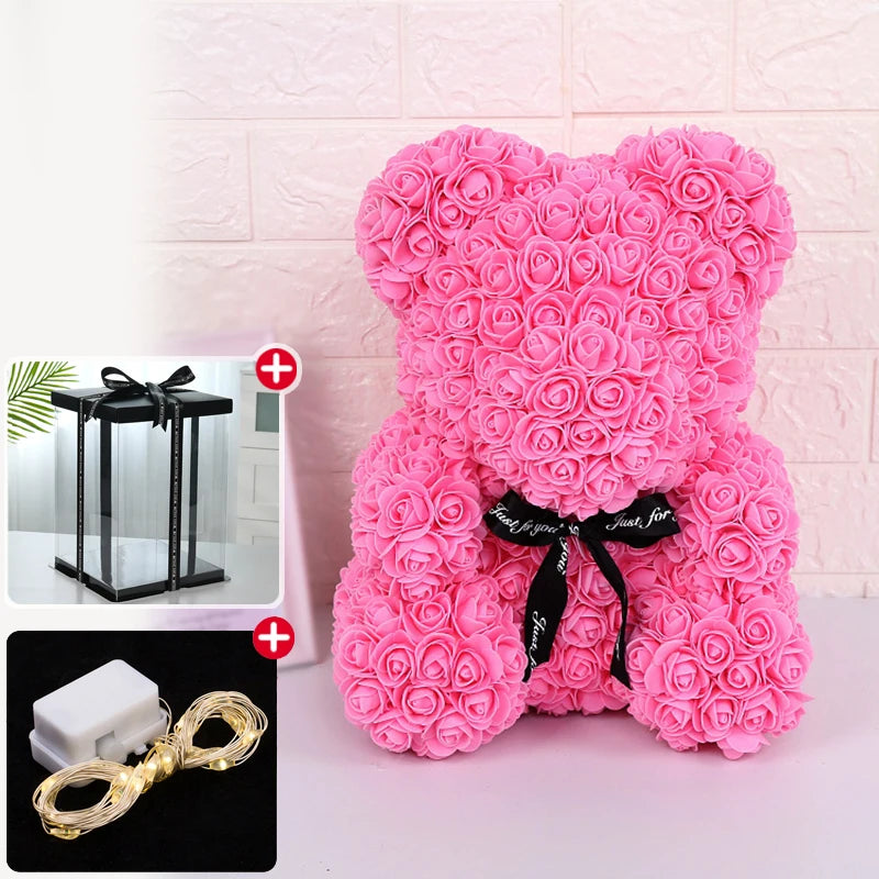 Un ours rose et duveteux en forme de rose avec un ruban noir et une décoration lumineuse LED.