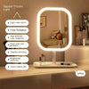 A white square tricolor light vanity mirror with an oval frame and a round LED light illuminating a bathroom counter.