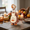 A handcrafted goose decoration wearing an apron and headband, set for autumn Thanksgiving decor.