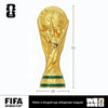 A gold FIFA World Cup trophy fridge magnet with a green base and a FIFA logo.