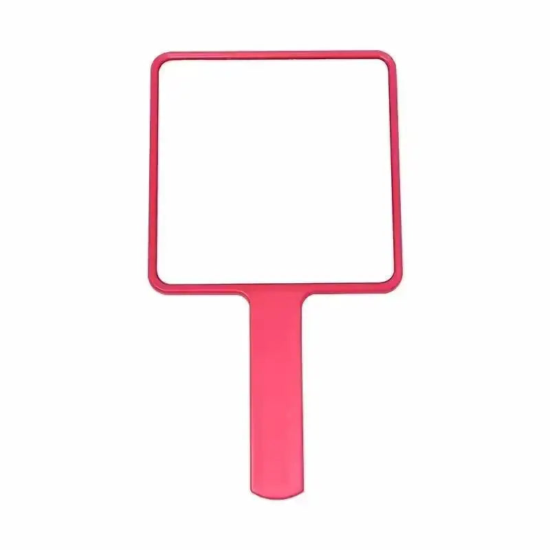 A pink compact handheld makeup mirror with an ergonomic handle.