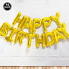 A golden foil balloon decoration set spelling out Happy Birthday mounted on a white door.