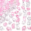A collection of pink and clear decorative crushed diamond acrylic pebbles.