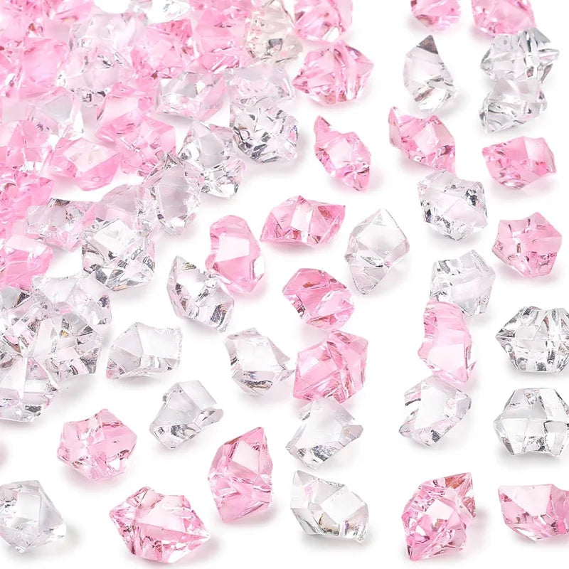 A collection of pink and clear decorative crushed diamond acrylic pebbles.