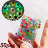 A hand holds a clear plastic bag filled with 50 colorful 3D resin ladybug nail art charms.