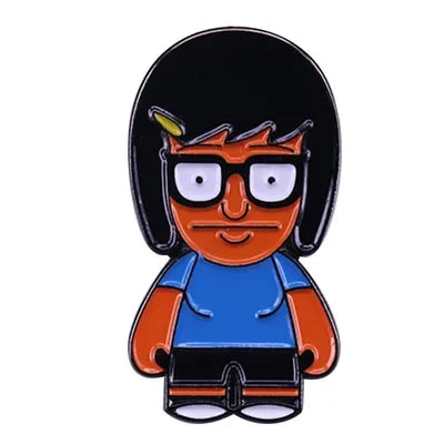 An enamel pin badge featuring a cartoon character with black hair, glasses, and an orange face against a blue shirt.