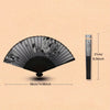 A black hand folding fan with floral patterns shown open and closed, next to a measuring stick.