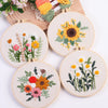 Five round embroidery pieces featuring floral designs in yellow, orange, and green thread on natural fabric.