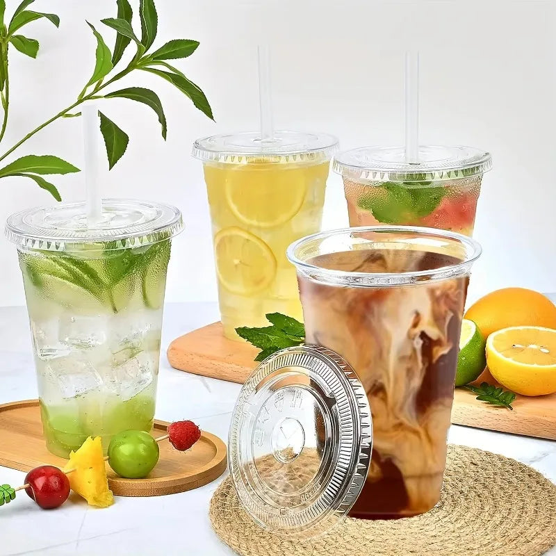 A glass of iced tea in a plastic cup surrounded by fresh fruit and leaves.