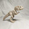 A white 3D printed figurine of a dinosaur skeleton, featuring a T-Rex and Mosasaurus collectible.