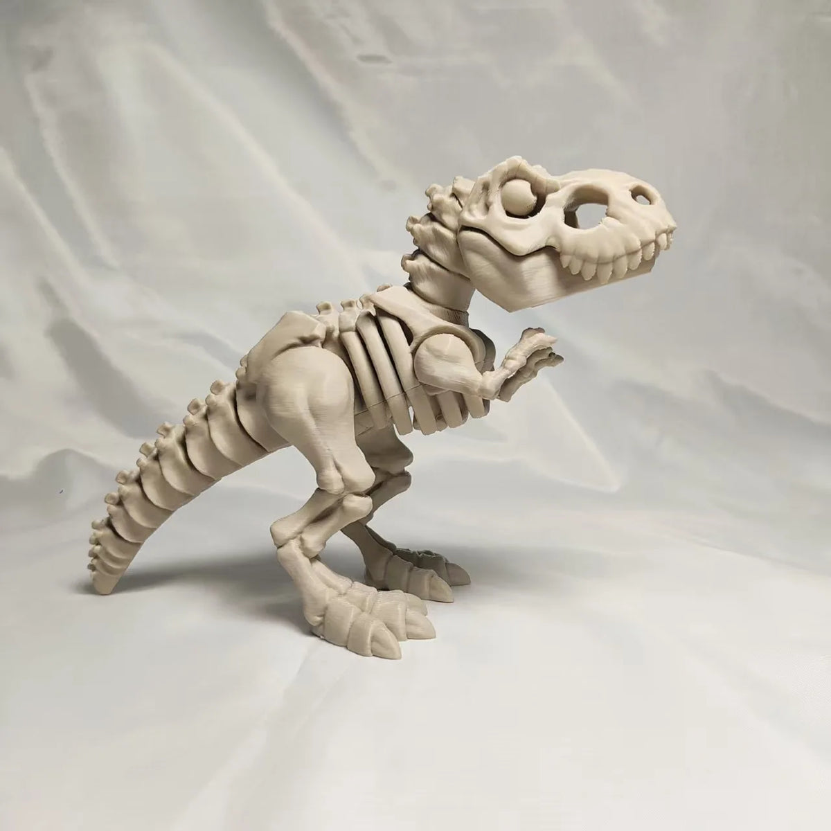 A white 3D printed figurine of a dinosaur skeleton, featuring a T-Rex and Mosasaurus collectible.