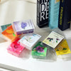 A collection of hand-poured soy wax aromatherapy gift sets in various colors and scents displayed on a white surface.