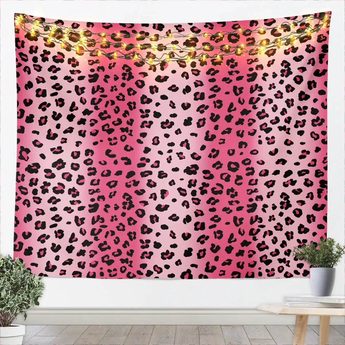 Pink leopard print tapestry wall hanging with warm string lights.