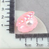 Pink mermaid cake toppers featuring iridescent shells and tails measured against a ruler.
