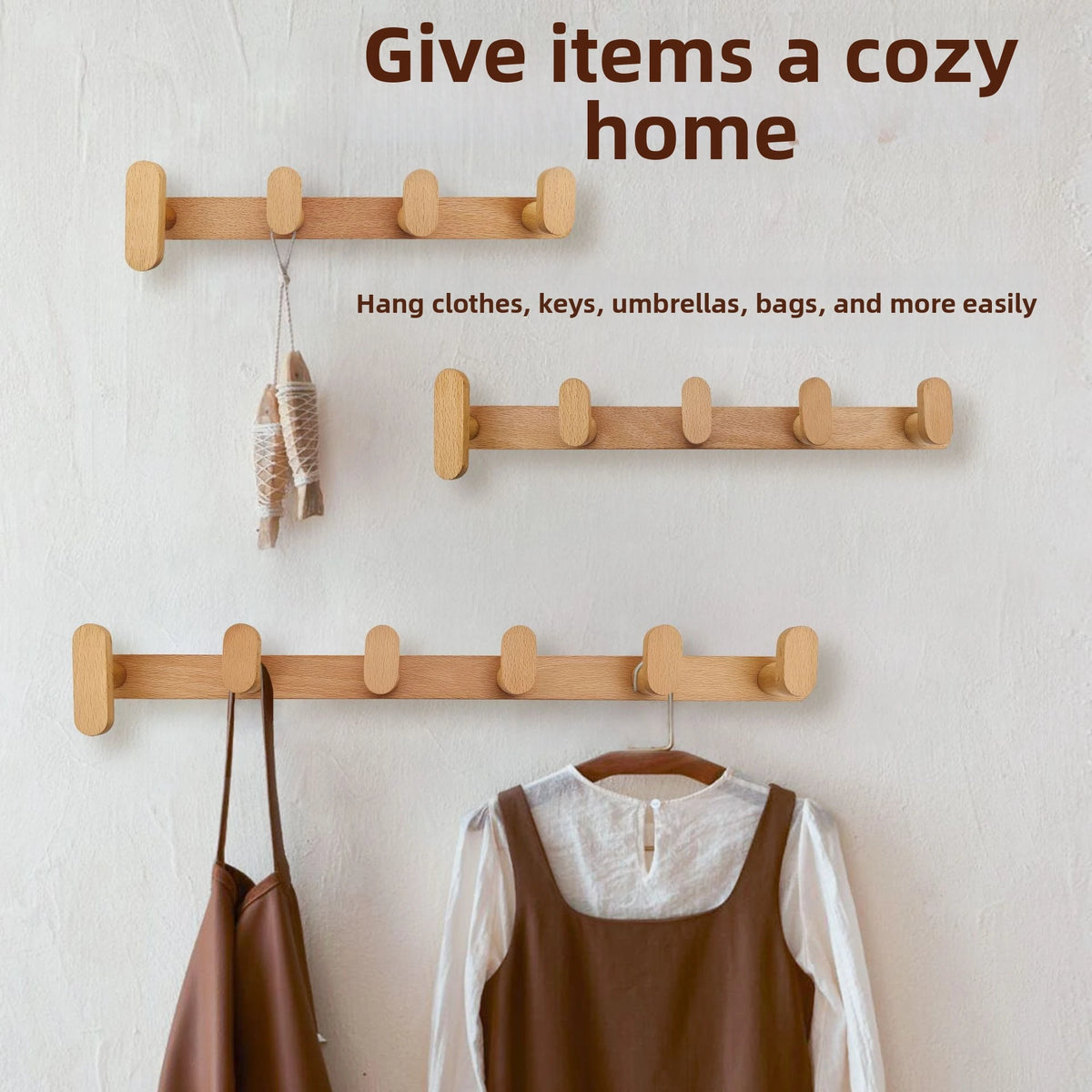 Wooden coat rack wall mount displaying various items like clothes, keys, umbrellas, and bags hanging on a white wall.